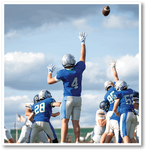 A football player wearing a black jersey with the number 6 on it. Description generated by AI