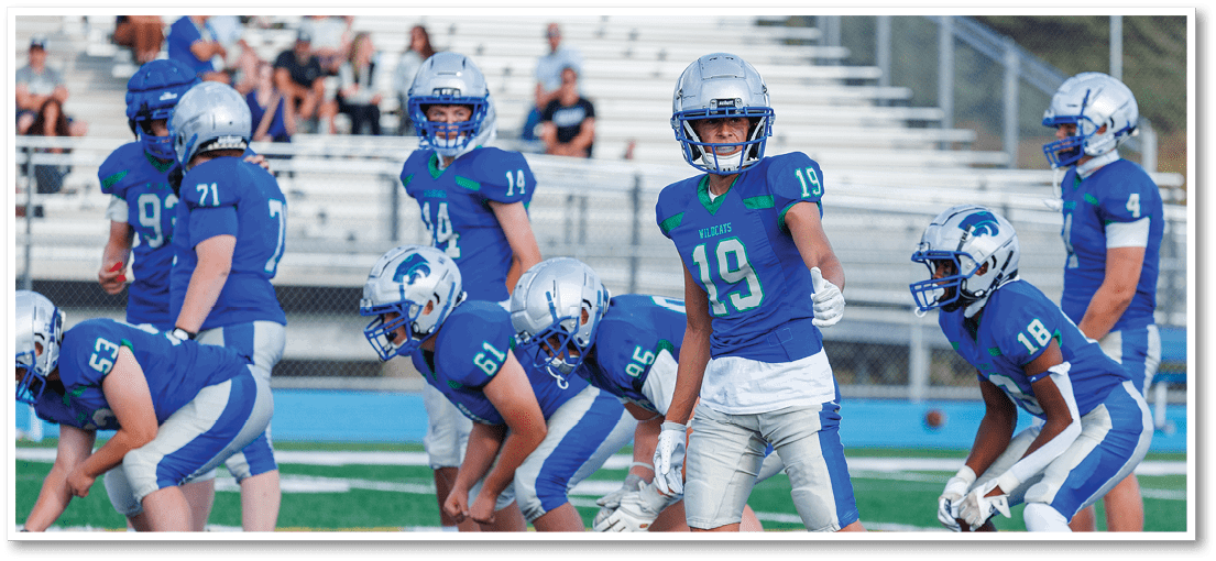 A group of football players on a field. Description generated by AI