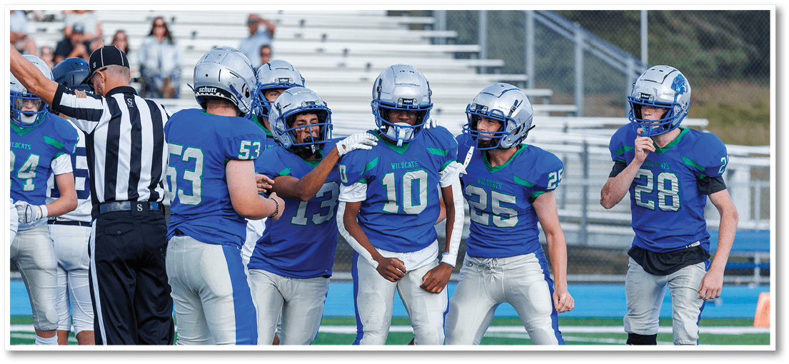 A group of football players on a field. Description generated by AI