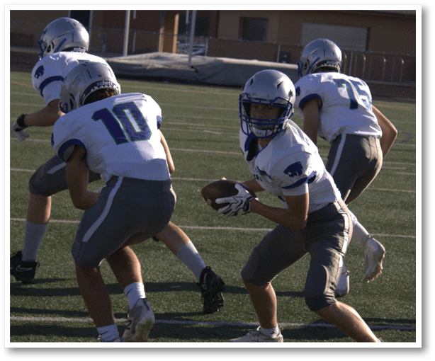 A group of football players wearing black jerseys with the number 3 on them. Description generated by AI
