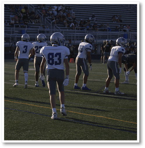 Two football players wearing black jerseys with the number 11 on them. Description generated by AI
