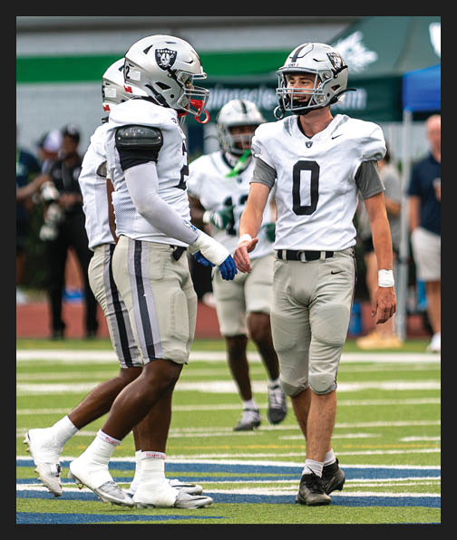 A football player in a white uniform is running with a football in his hand. AI generated content