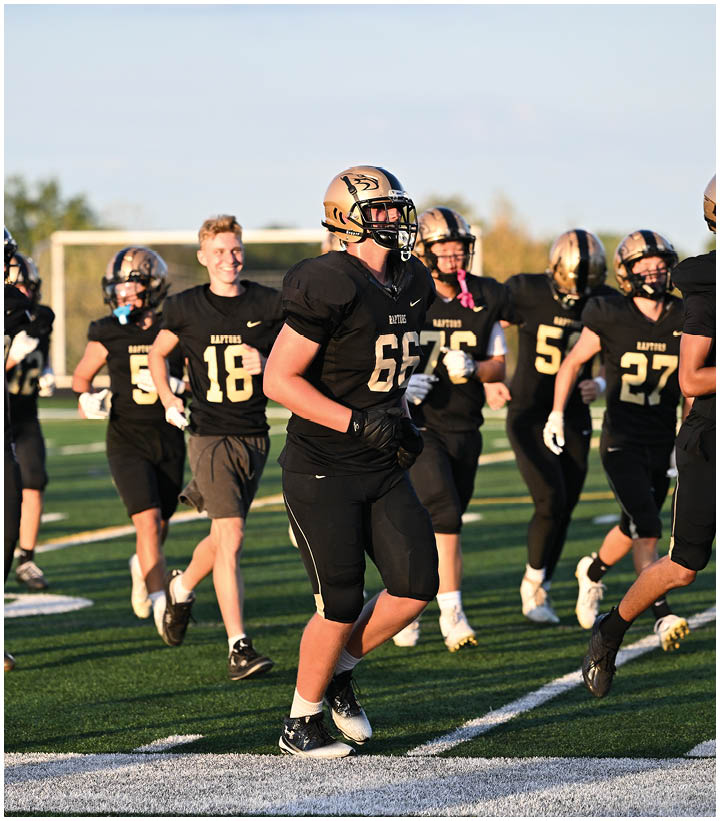 A group of football players wearing black and white uniforms. Description generated by AI