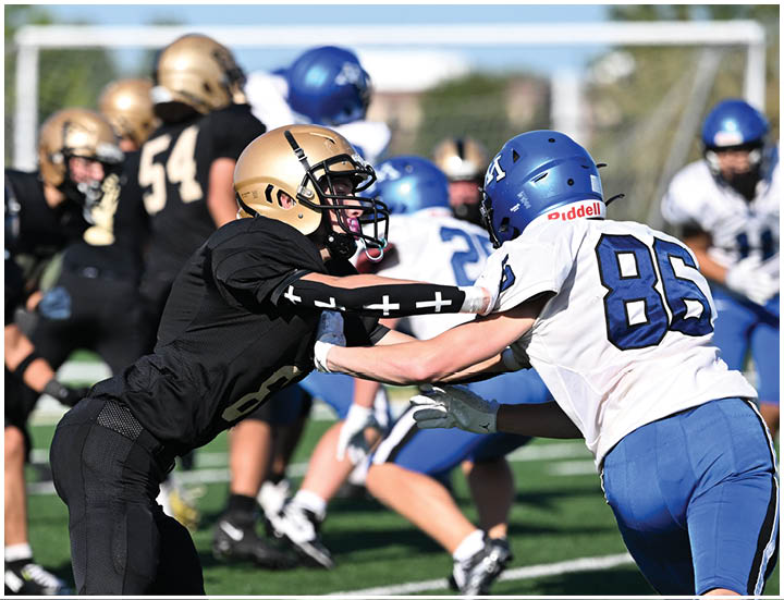 A group of football players wearing black and white uniforms. Description generated by AI