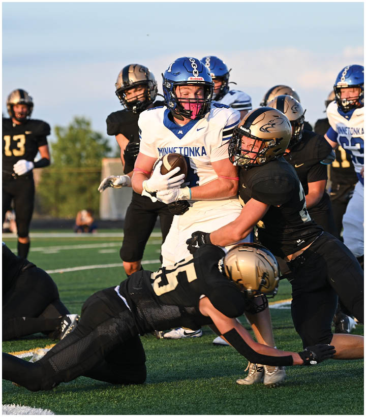A group of football players wearing black and white uniforms. Description generated by AI