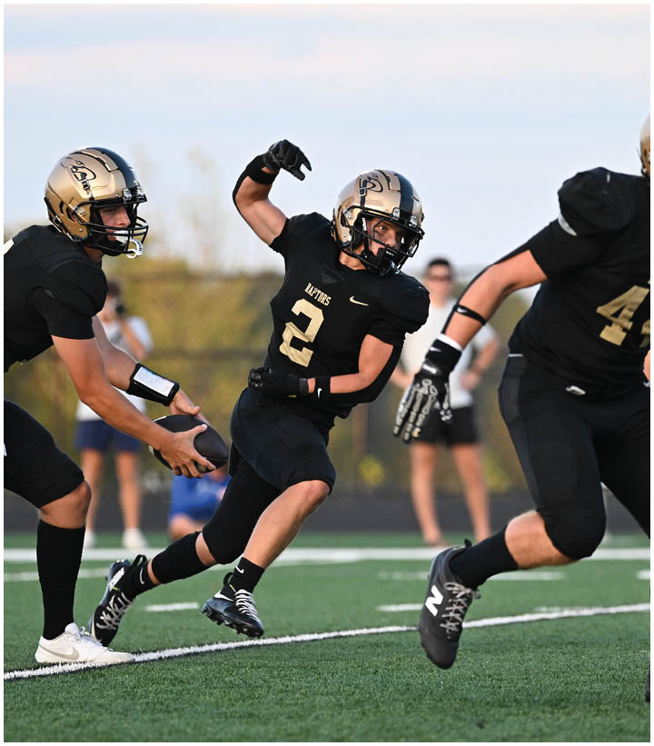 A group of football players wearing black and white uniforms. Description generated by AI