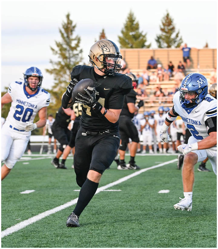 A group of football players wearing black and white uniforms. Description generated by AI