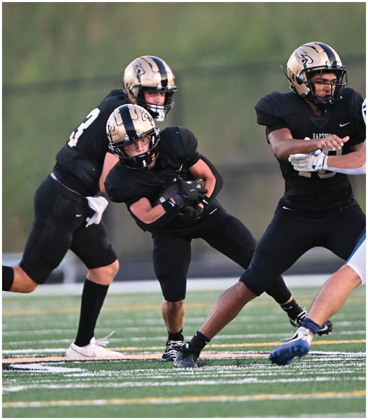 A group of football players wearing black and white uniforms. Description generated by AI