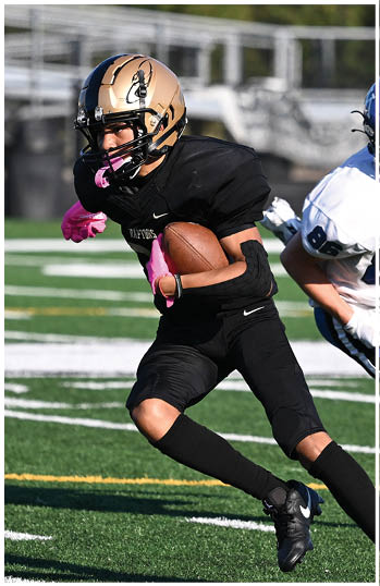 A football player running on the field. Description generated by AI