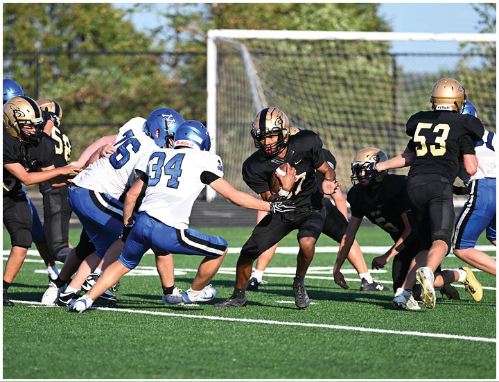 A group of football players wearing black and white uniforms. Description generated by AI