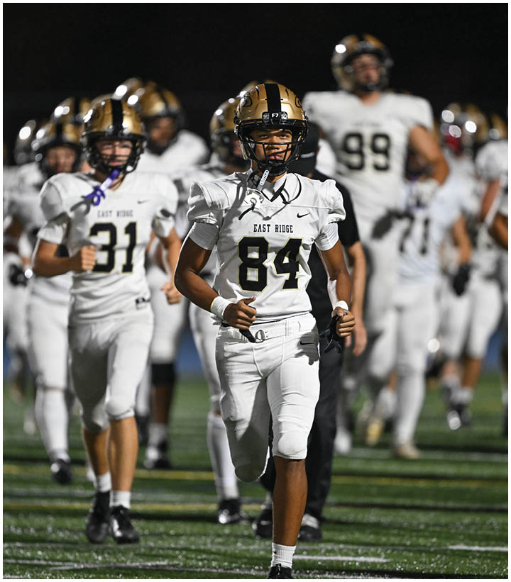 A group of football players wearing black and white uniforms. Description generated by AI