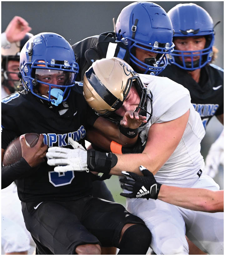 A group of football players wearing black and white uniforms. Description generated by AI