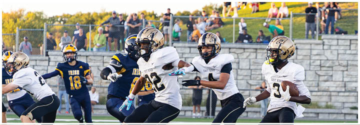 A group of football players on a field. Description generated by AI