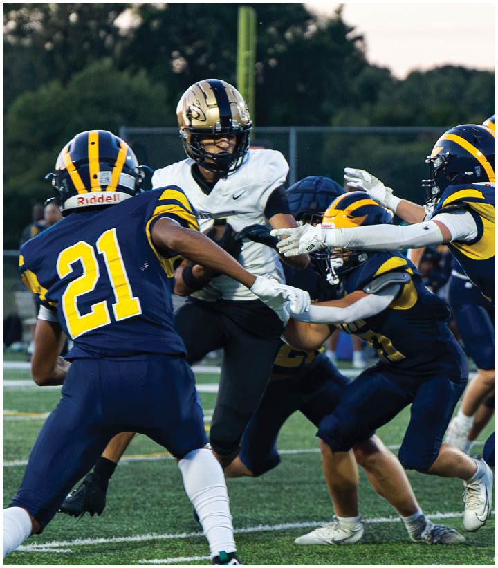 A group of football players wearing black and white uniforms. Description generated by AI