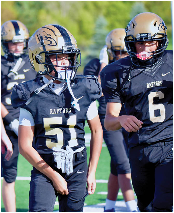 A group of football players wearing black and white uniforms. Description generated by AI