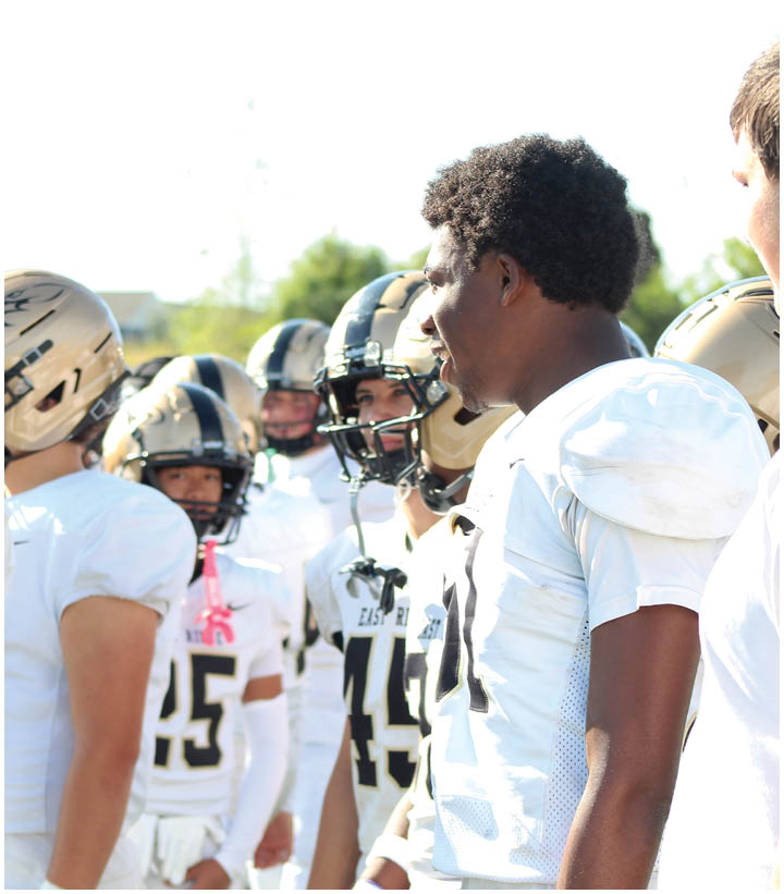 A group of football players wearing black and white uniforms. Description generated by AI