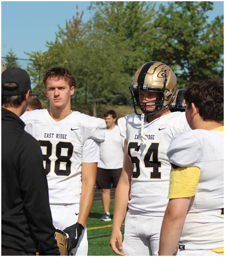A group of football players wearing black and white uniforms. Description generated by AI