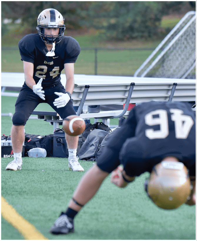 A group of football players wearing black and white uniforms. Description generated by AI