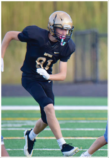 A football player running on the field. Description generated by AI