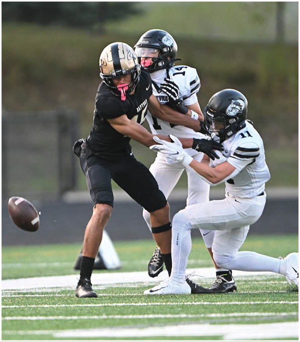 A group of football players wearing black and white uniforms. Description generated by AI