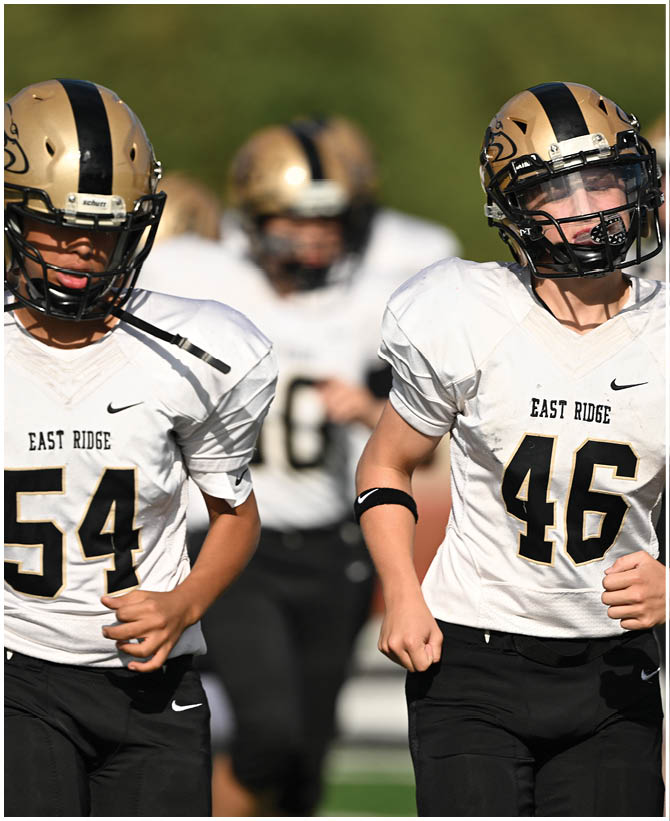 A group of football players wearing black and white uniforms. Description generated by AI