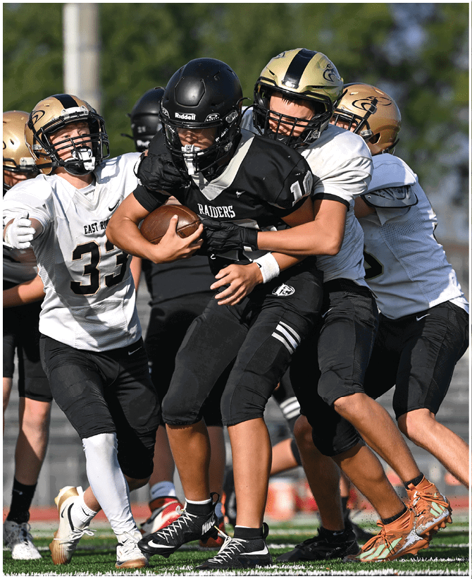 A group of football players wearing black and white uniforms. Description generated by AI