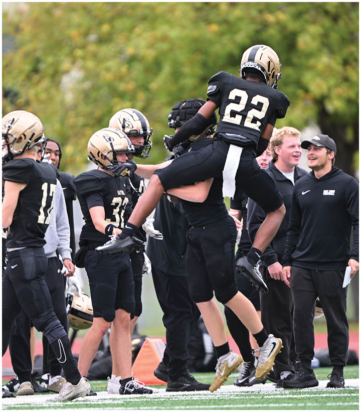 A group of football players wearing black and white uniforms. Description generated by AI