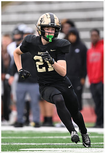 A football player running on the field. Description generated by AI