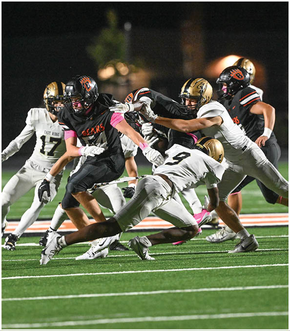 A group of football players wearing black and white uniforms. Description generated by AI