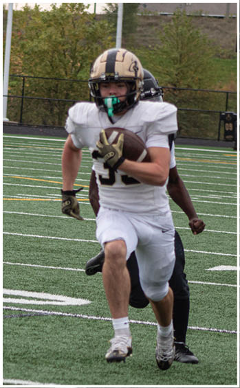 A football player running on the field. Description generated by AI