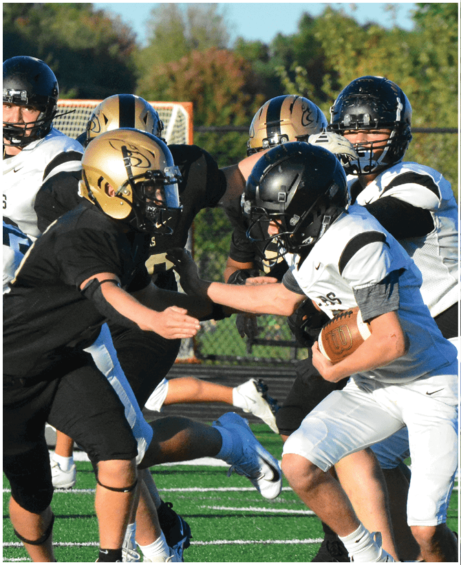 A group of football players wearing black and white uniforms. Description generated by AI