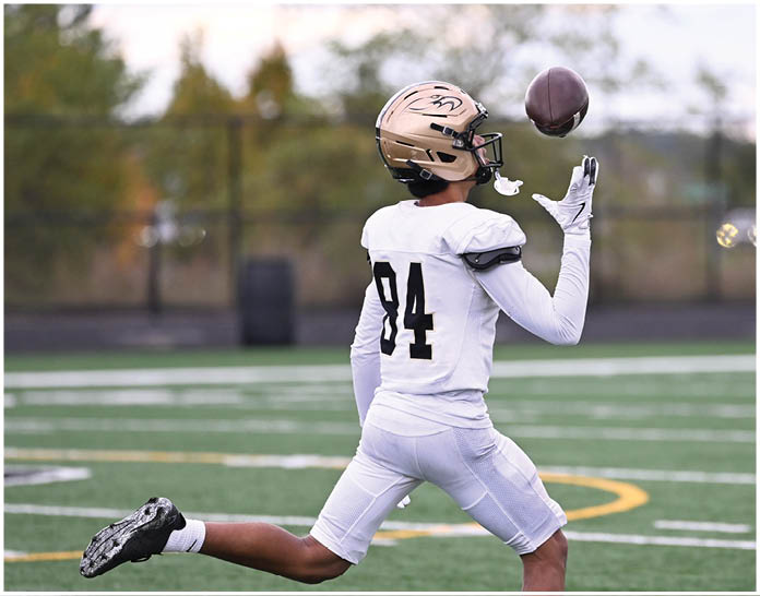 A group of football players wearing black and white uniforms. Description generated by AI