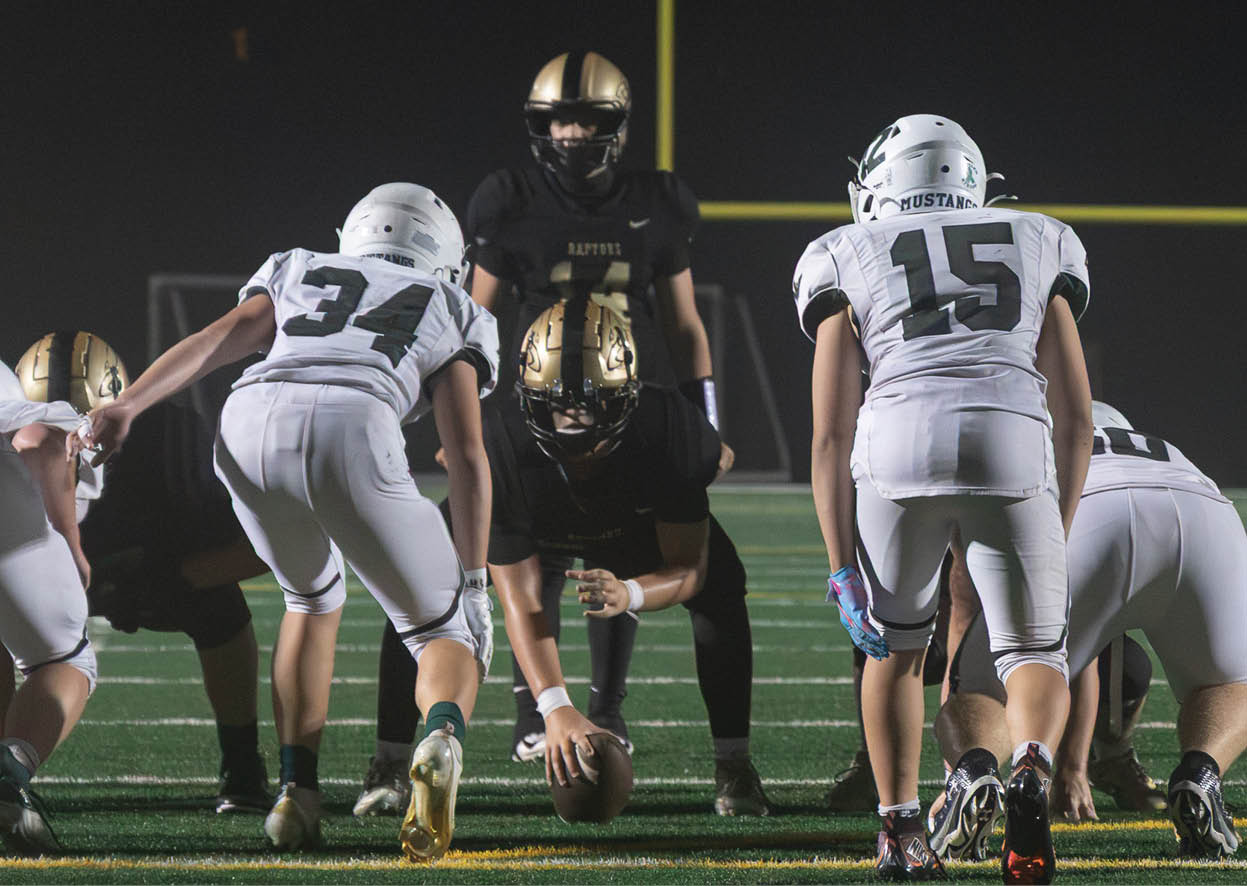A group of football players wearing black and white uniforms. Description generated by AI
