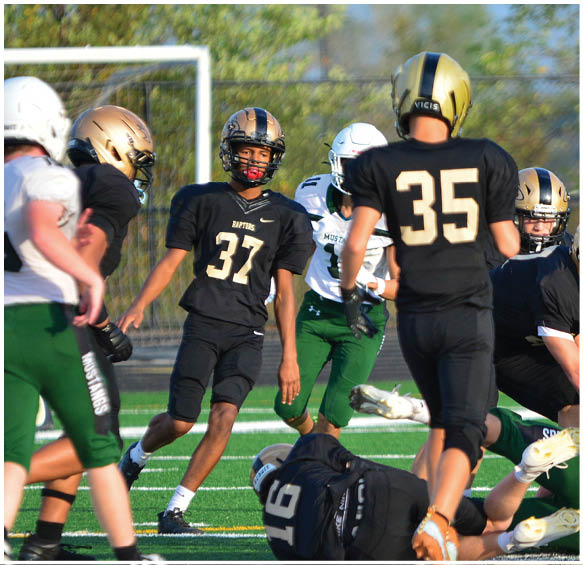 A group of football players wearing black and white uniforms. Description generated by AI