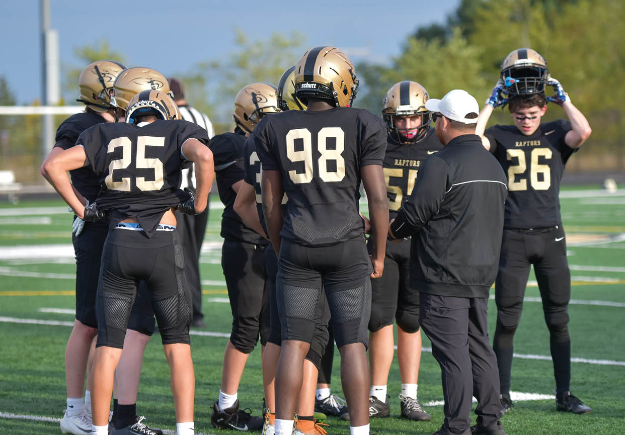 A group of football players wearing black and white uniforms. Description generated by AI