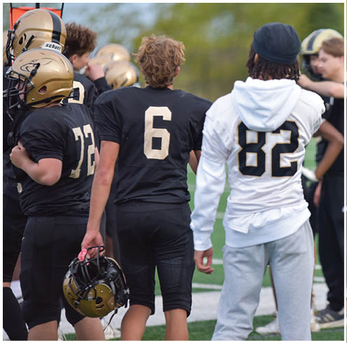 A group of football players wearing black and white uniforms. Description generated by AI