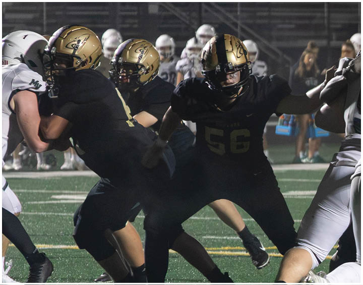 A group of football players wearing black and white uniforms. Description generated by AI