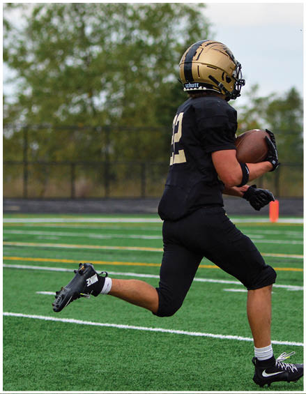 A football player running on the field. Description generated by AI