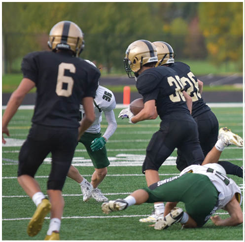 A group of football players wearing black and white uniforms. Description generated by AI