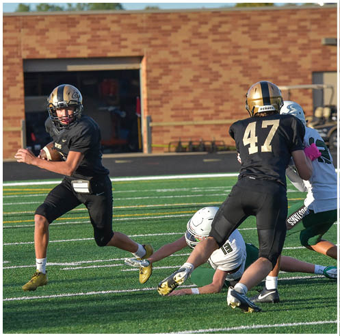 A group of football players wearing black and white uniforms. Description generated by AI