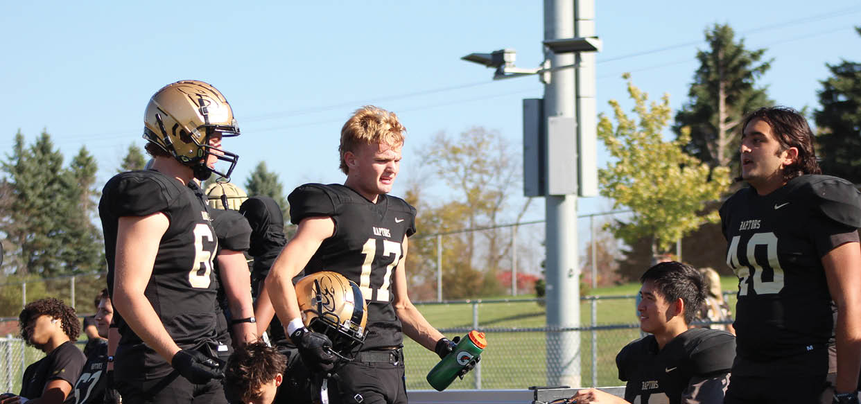 A group of football players wearing black and white uniforms. Description generated by AI