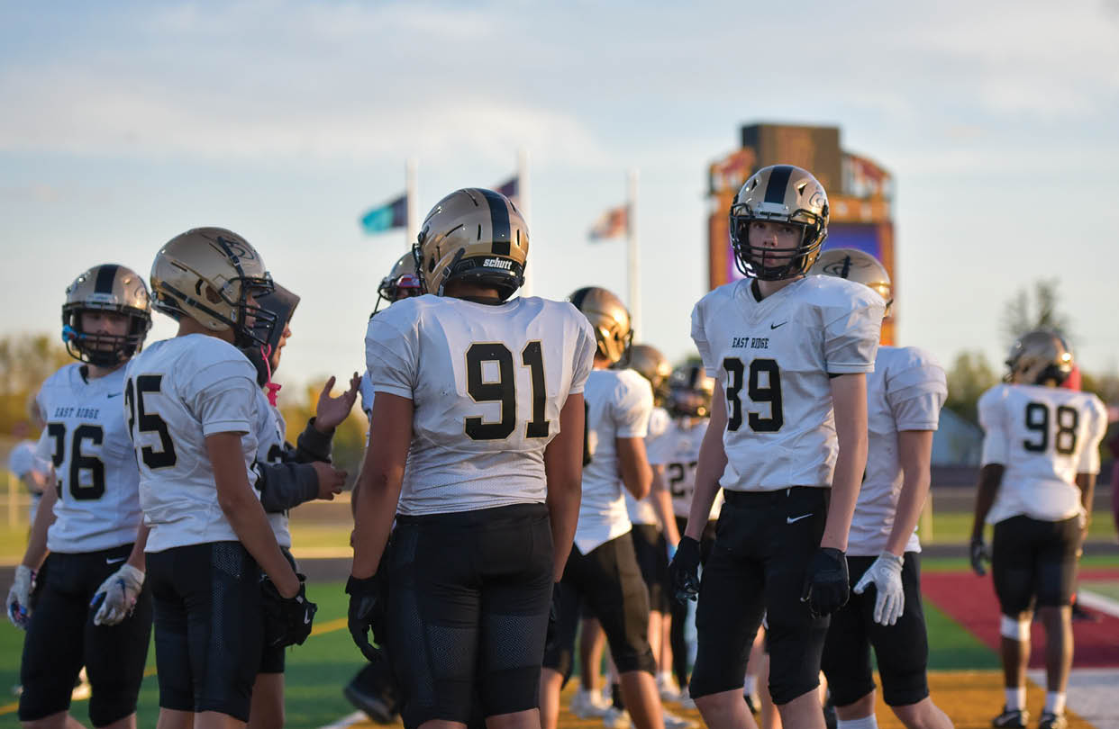 A group of football players wearing black and white uniforms. Description generated by AI
