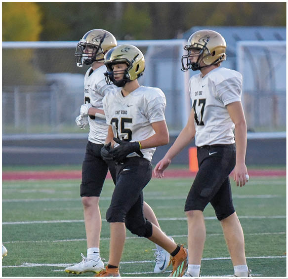 A group of football players wearing black and white uniforms. Description generated by AI
