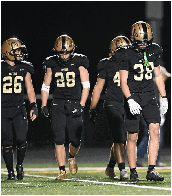 A group of football players wearing black and white uniforms. Description generated by AI