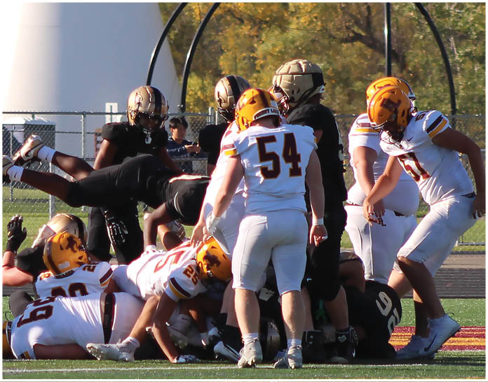A group of football players wearing black and white uniforms. Description generated by AI