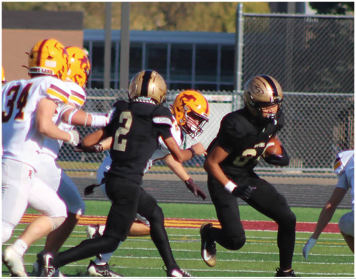 A group of football players wearing black and white uniforms. Description generated by AI