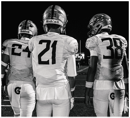 A football game is taking place with a group of men on the field. Description generated by AI