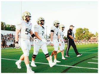 A group of football players on a field. Description generated by AI