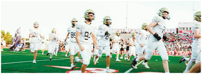 A group of football players on a field. Description generated by AI