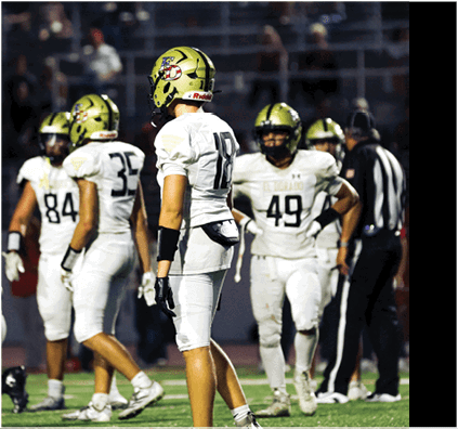 A group of football players on a field. Description generated by AI
